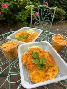 Kotlet z marchewką na zielonym stoliku w pojemniku