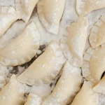 Pierogi na blacie posypane mąką