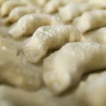 Pierogi na blacie posypane mąką