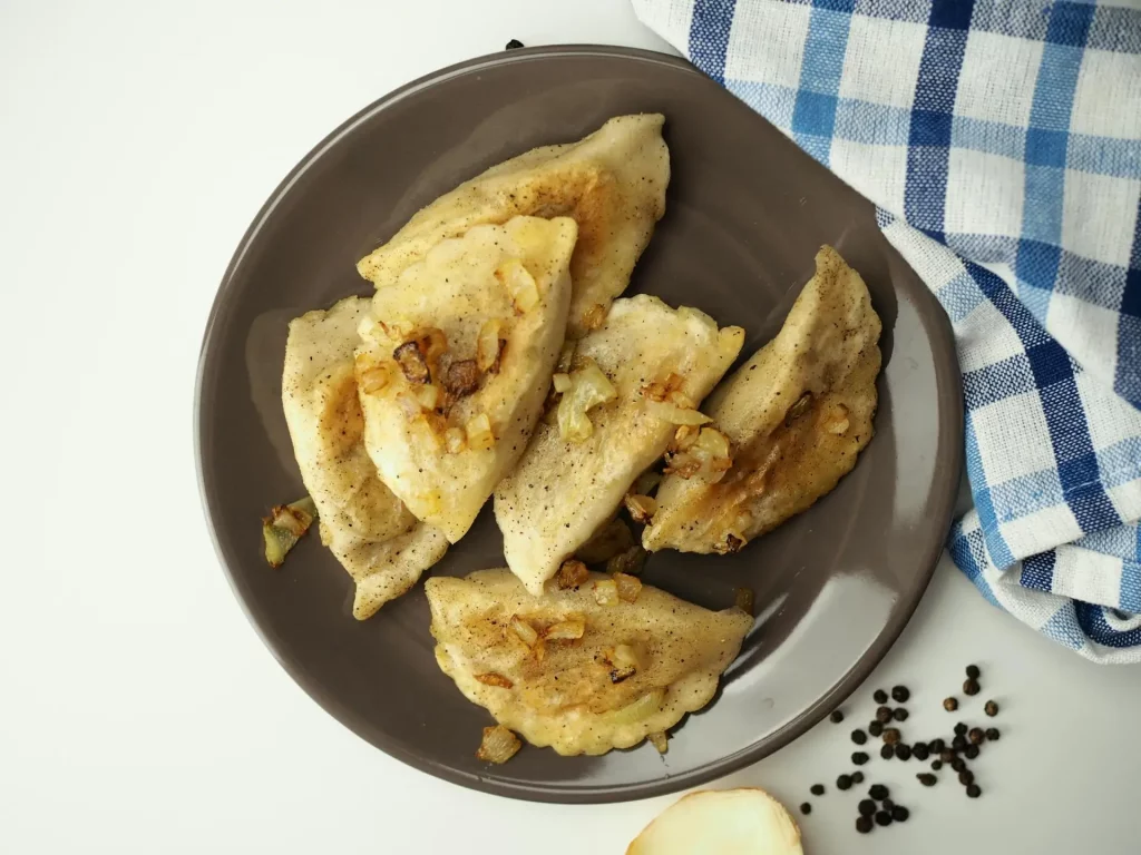 Smażone pierogi z cebulką na talerzu