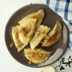 Smażone pierogi z cebulką na talerzu